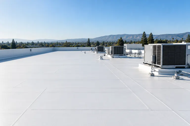 Illustrative: a broad white membrane commercial roof with rooftop units